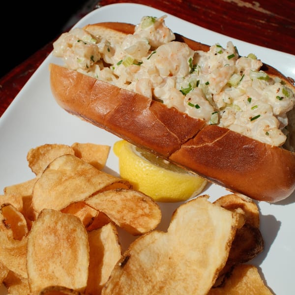 Cowgirl Kitchen's shrimp roll with a side of crispy potato chips and a lemon wedge.